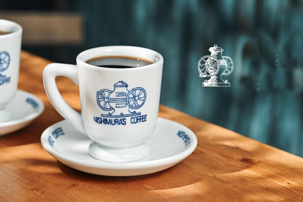 Close-up of Nishimura's Coffee cup with vintage grinder logo